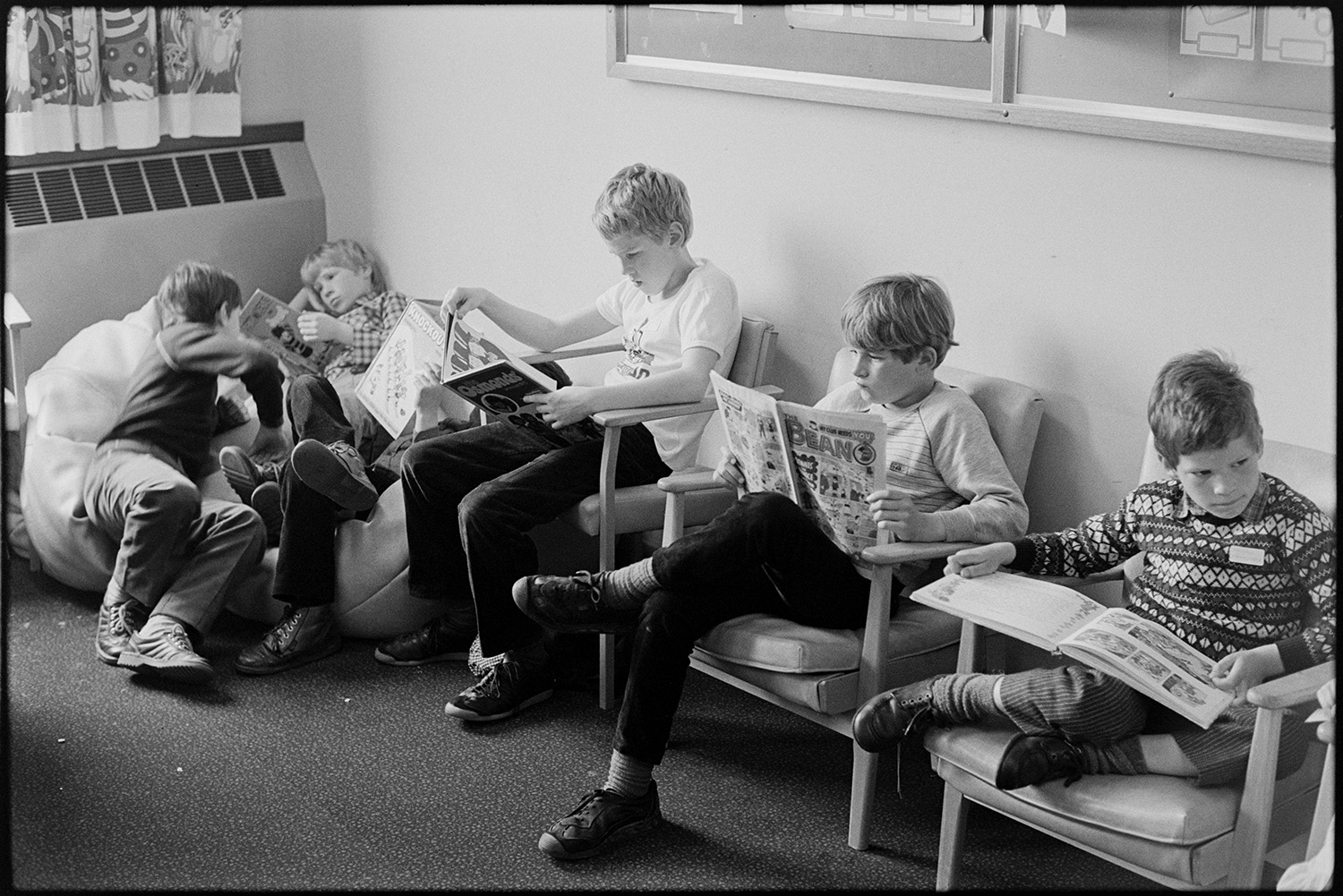 Ward Sister and nurses in ward of hospital. 
[Five boys sat on chairs and beanbags reading books and magazines in the Children's Ward at Barnstaple General Hospital. One boy is reading the Beano comic.]