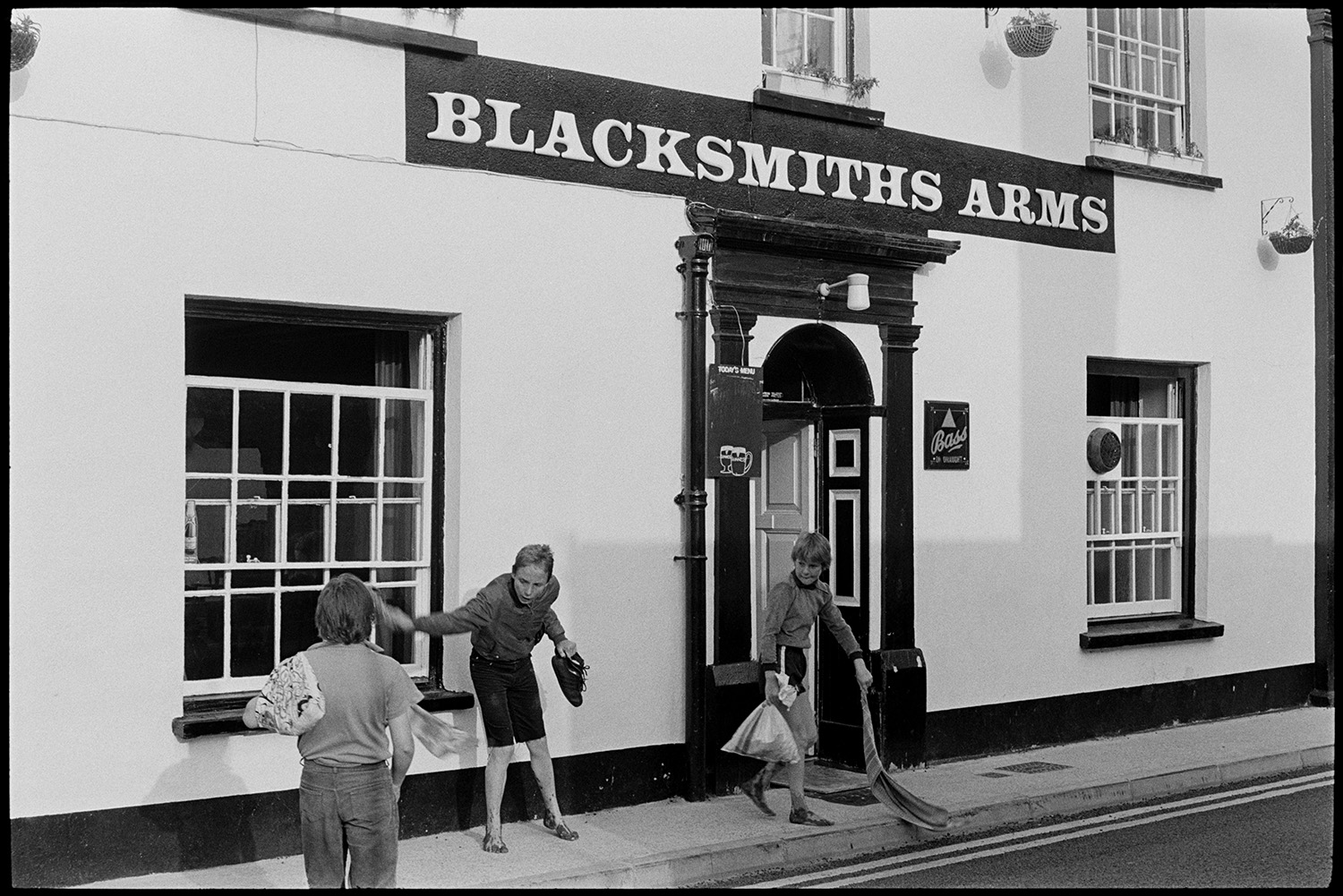 Front of pub, doorway and sign. 
[Three children playing outside the front door of the Blacksmiths Arms pub in East the Water, Bideford.]