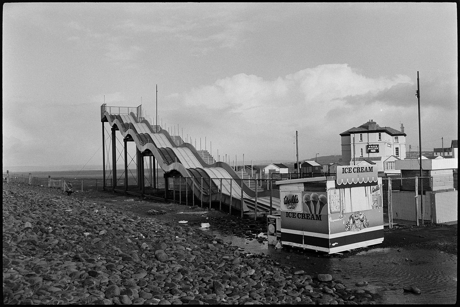 Giant slide at seaside. Out of season.
[The 'Astroglide' giant slide and ice cream kiosk behind the pebble ridge at Westward Ho!.]