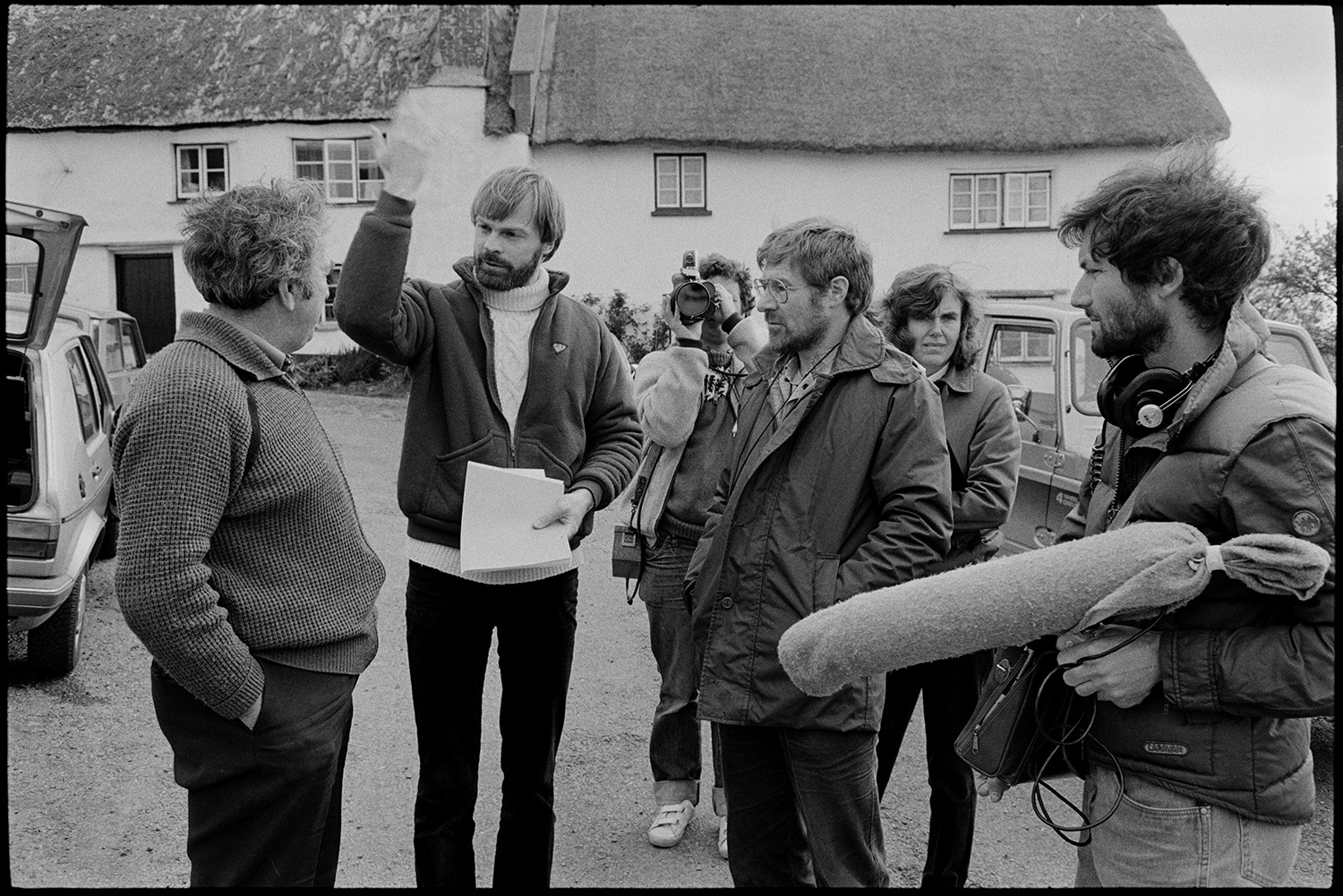 Club Day, BBC film crew with director.
[Tony Byers with a BBC film crew talking to a man at Iddesleigh Club Day in front of thatched cottages. He is waving his hand in the air.]