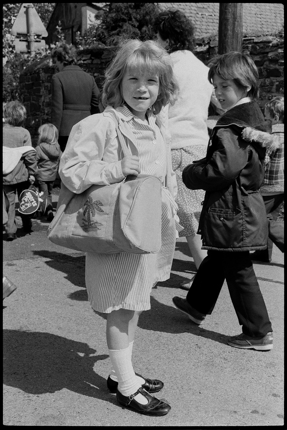 Schoolchildren after school, girls.<br />
[Nicky Squire leaving Dolton Primary School, carrying a holdall bag. Other children and women can be seen behind her.]