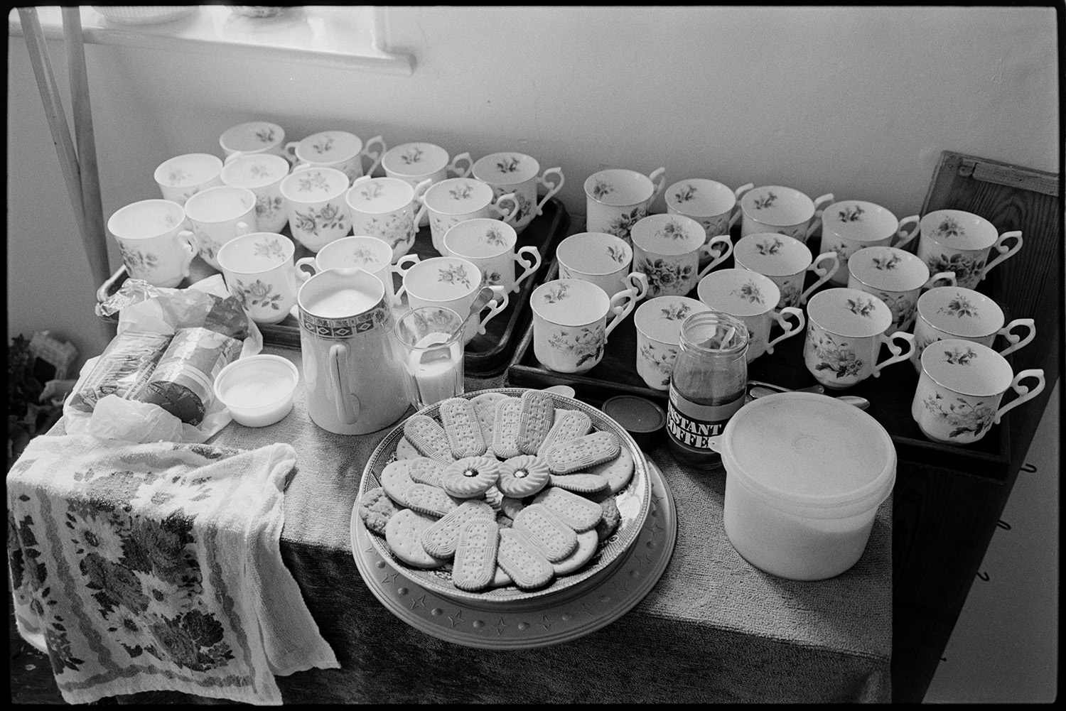 Baptist Chapel flower festival Minister playing organ, harmonium, mugs and biscuits, teas.
[Table on which are cups are laid out on trays with milk, sugar in a bowl, a jar of instant coffee, biscuits arranged on a plate and a floral teacloth, at the Dolton Baptist Chapel flower festival.]