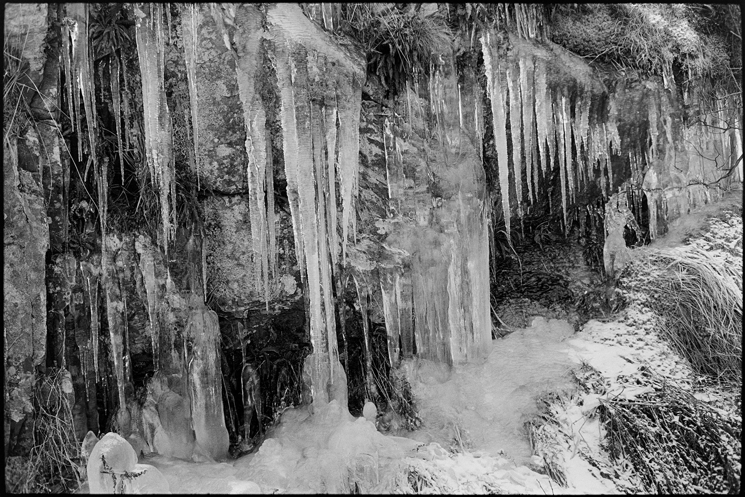 Snow, icicles at moor roadside.
[Snow and icicles on the roadside near Simonsbath on Exmoor.]