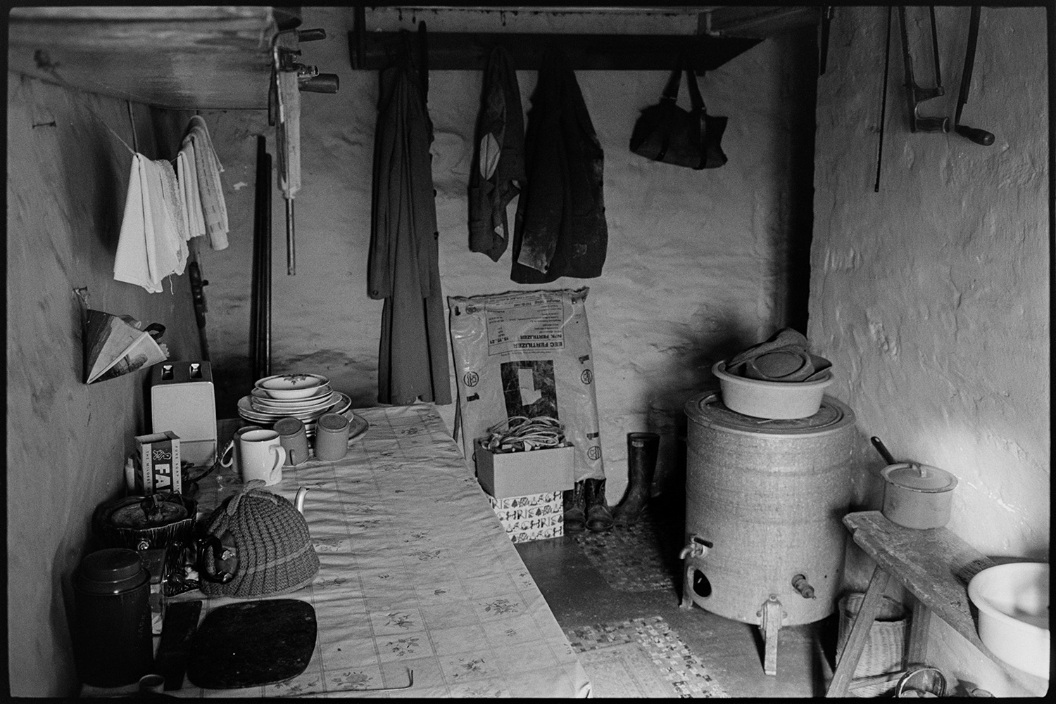 Interior of kitchen, gas boiler, utensils etc. 
[The interior of the kitchen at Bottreaux Mill, Molland with a gas boiler and table. A teapot, plates, toaster and mugs can be seen on the table. Towels are also hung up to dry.]