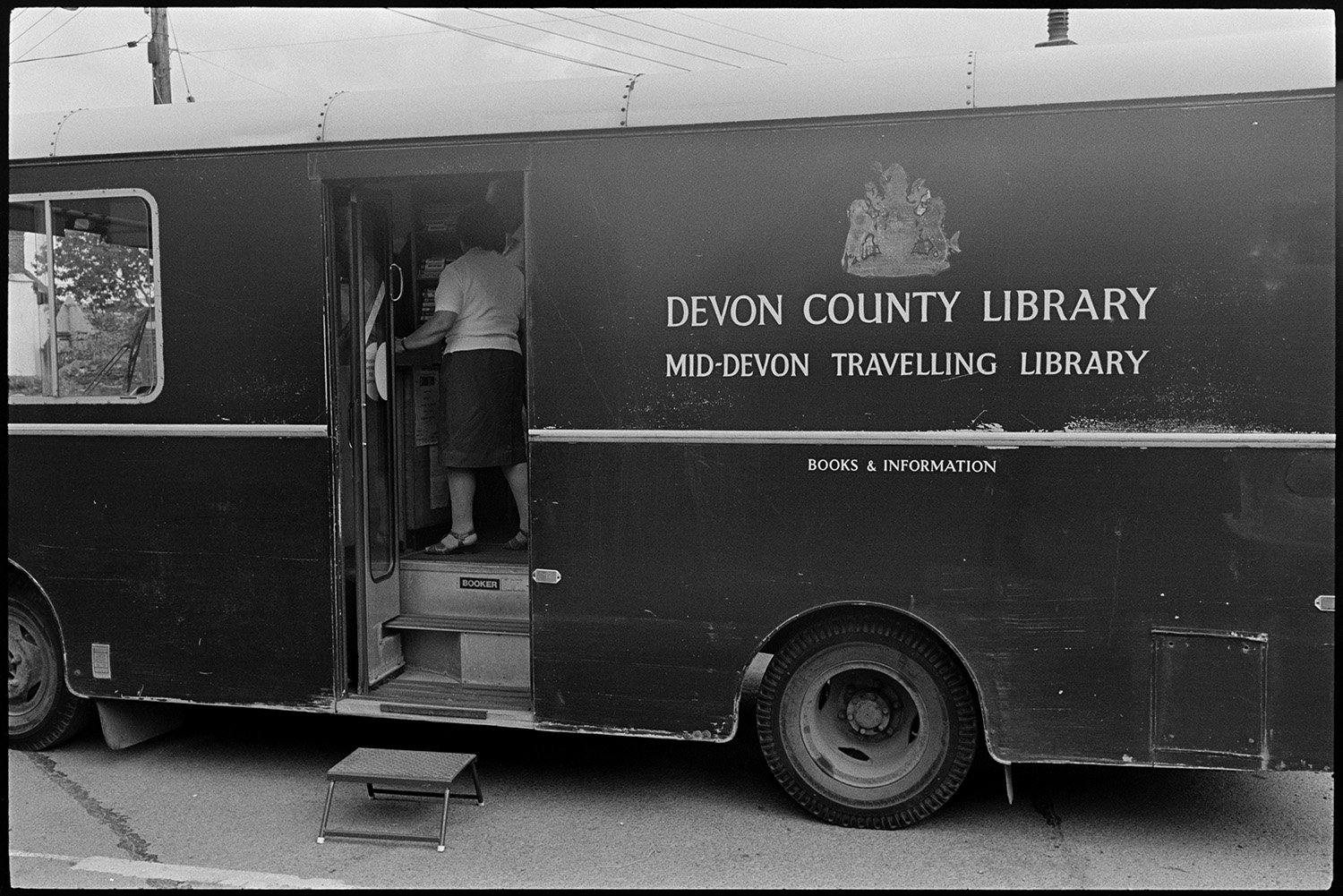 Library van parked in village, women and children after school. 
[The exterior of a library van parked in a street in Dolton. A woman can be seen inside the open doorway.]