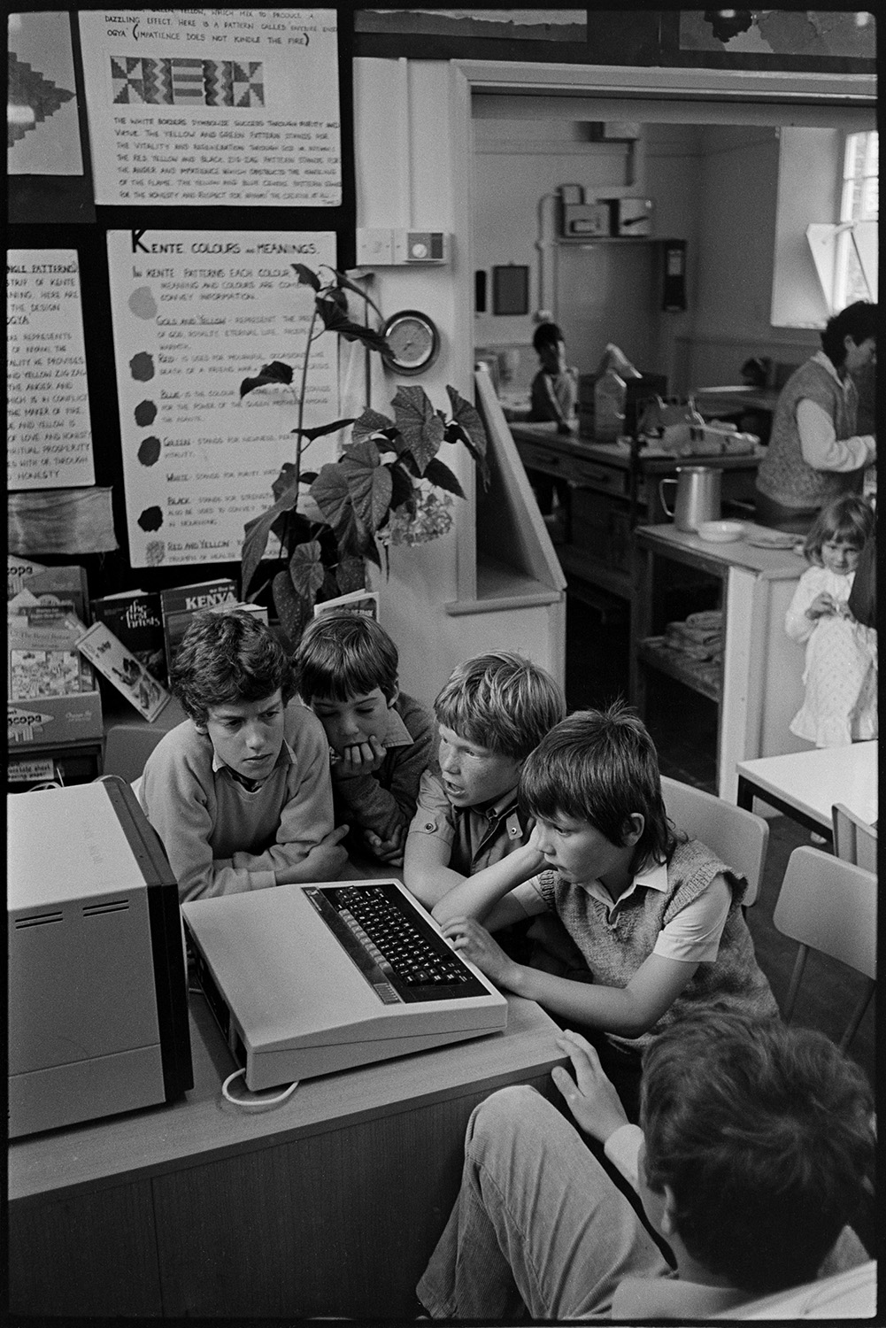 School open day, child showing computer to older woman. 
[A group of boys using the BBC computer in a classroom at Dolton Primary School open day.]