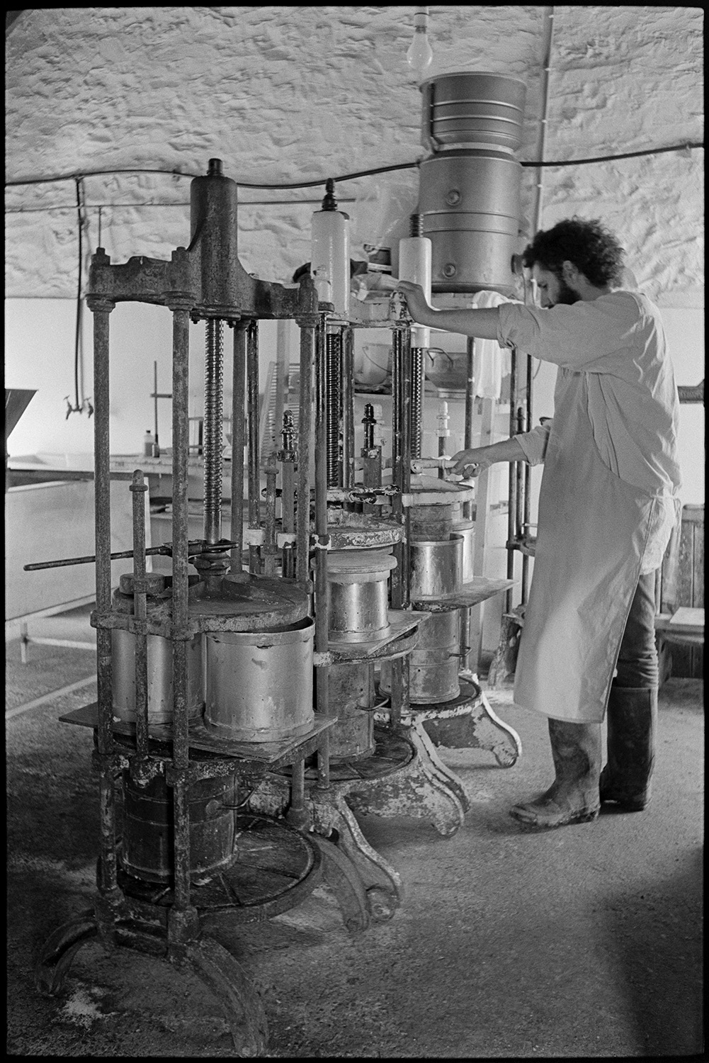 Man making cheese in dairy. 
[Peter Charnley making cheese in vats in the dairy at Park Farm, Umberleigh.]