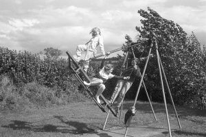 Children playing on the swings by James Ravilious