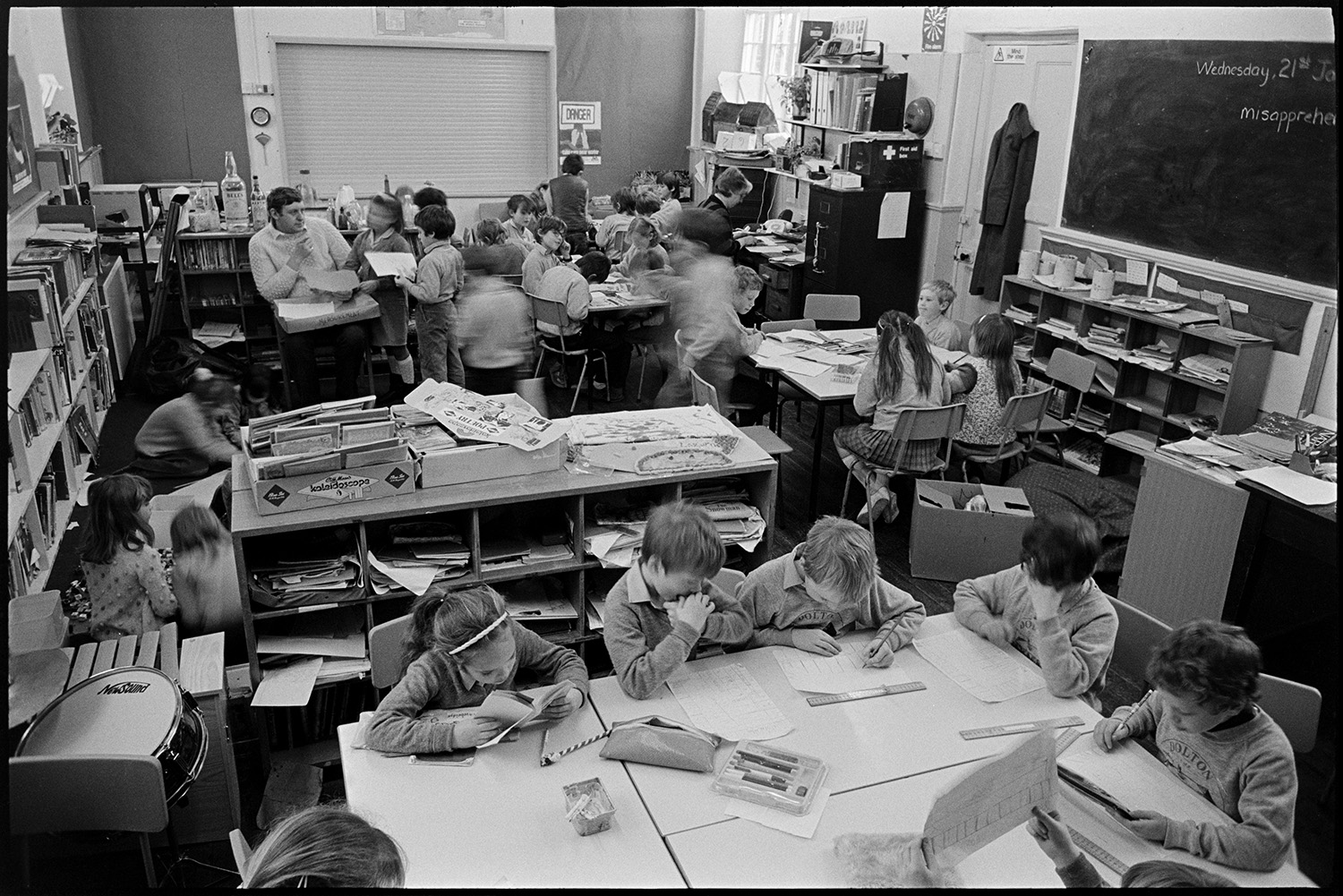 Interior of primary school with children at work, to show crowding to get new building.
[Interior of Dolton Primary School showing a classroom with children and teachers working at tables surrounded by bookshelves. The image was taken to demonstrate overcrowding in the school.]