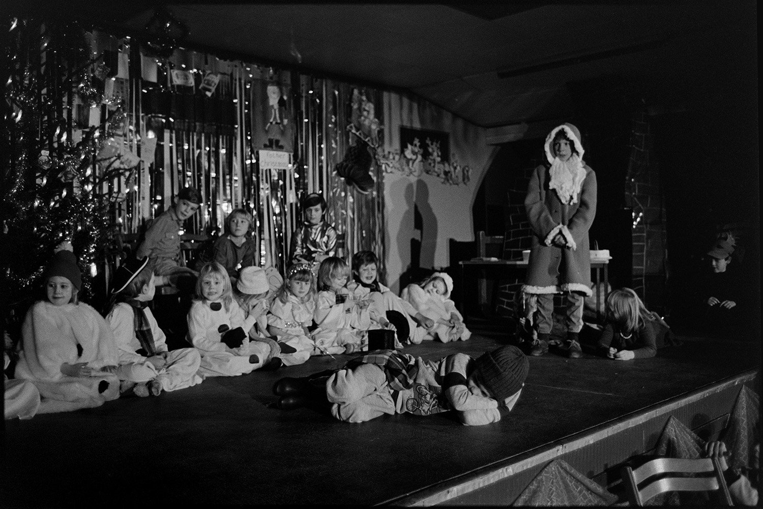 Christmas show in village hall Nativity play, children performing.
[Children performing in a Christmas show on the stage in Dolton Village Hall. One child is dressed as Father Christmas.]