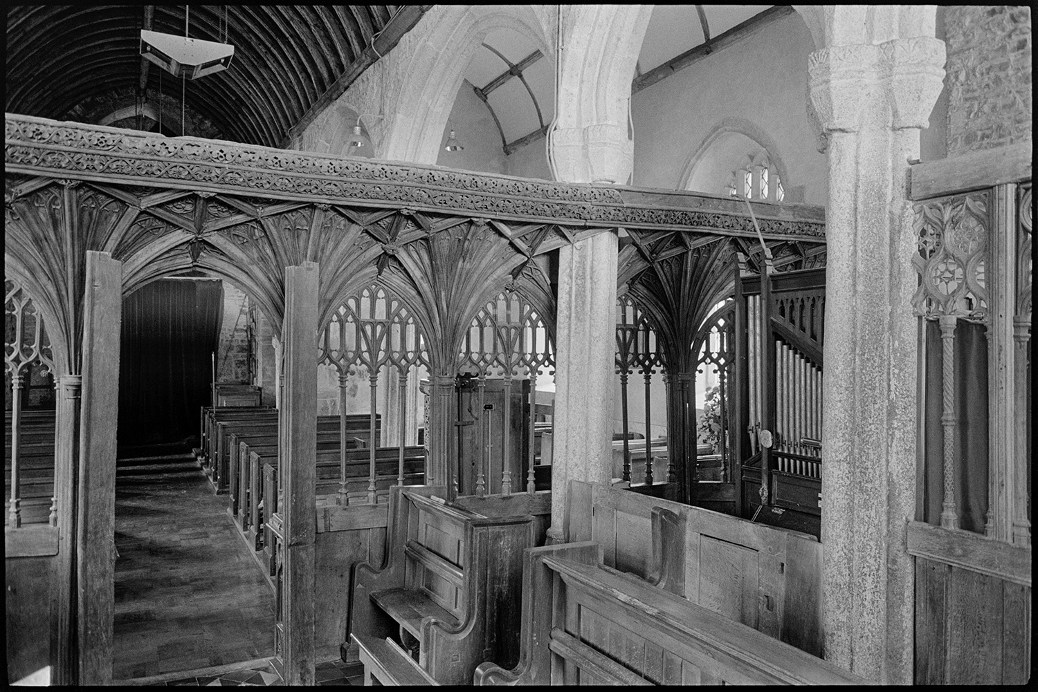 Church interior, tomb, screen.
[The interior of Coldridge church, showing a carved rood screen, wooden pews, an organ and a pulpit.]