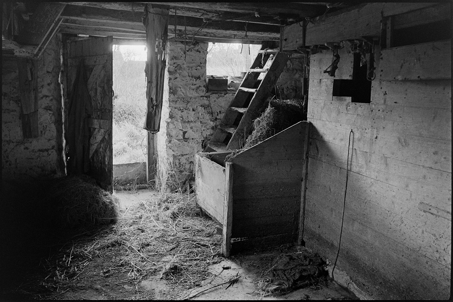 Views inside and outside of mill showing wheel and machinery and workshop. Stored nitches thatch.<br />
[Interior of Rashleigh Mill, Bridge Reeve, showing the entrance, steps leading to the first floor and a storage bin containing hay.]