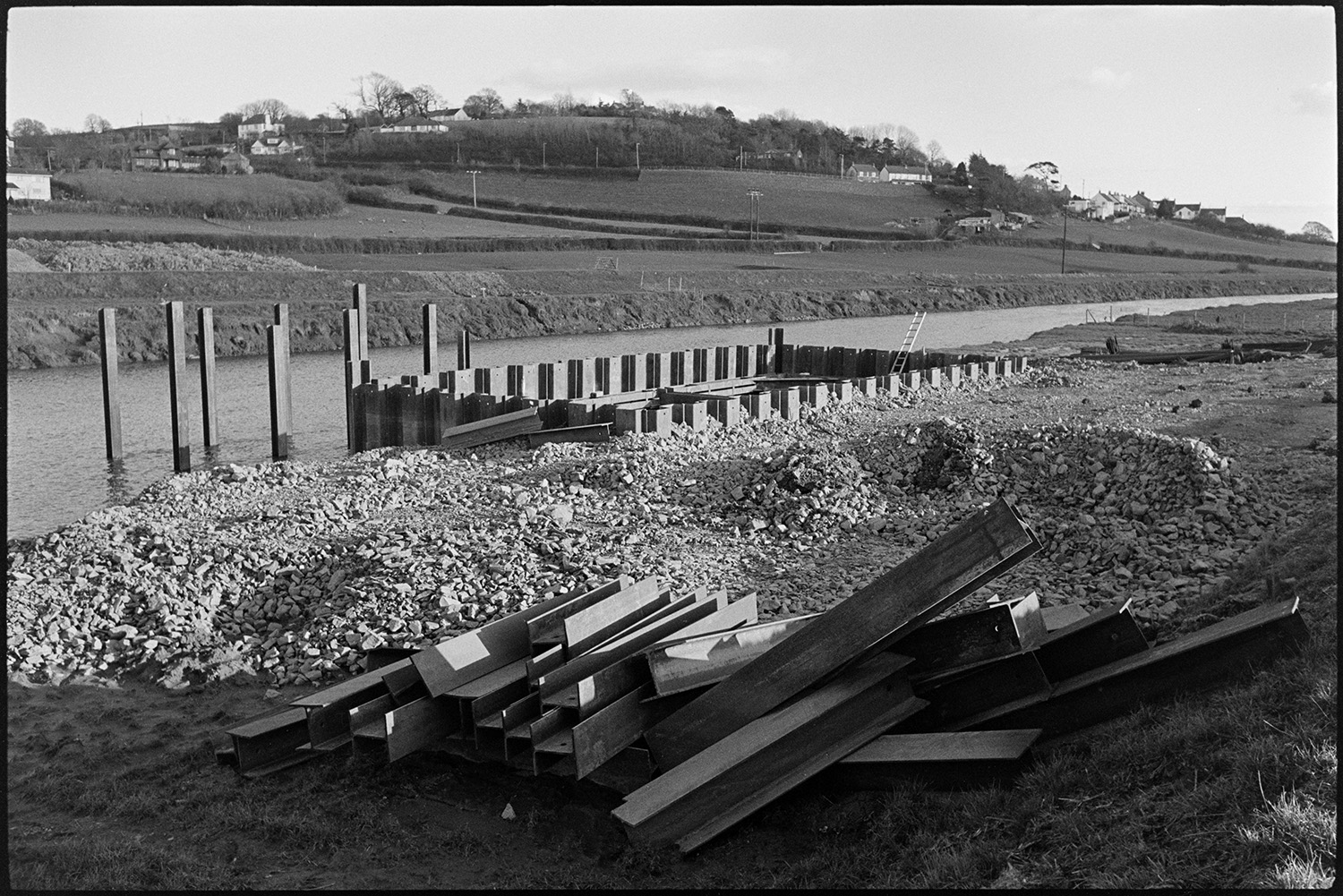 Engineers working on new river bridge for motorway link road.
[Steel girders and piles on the bank of the River Taw near Barnstaple being used in the construction of a bridge.]