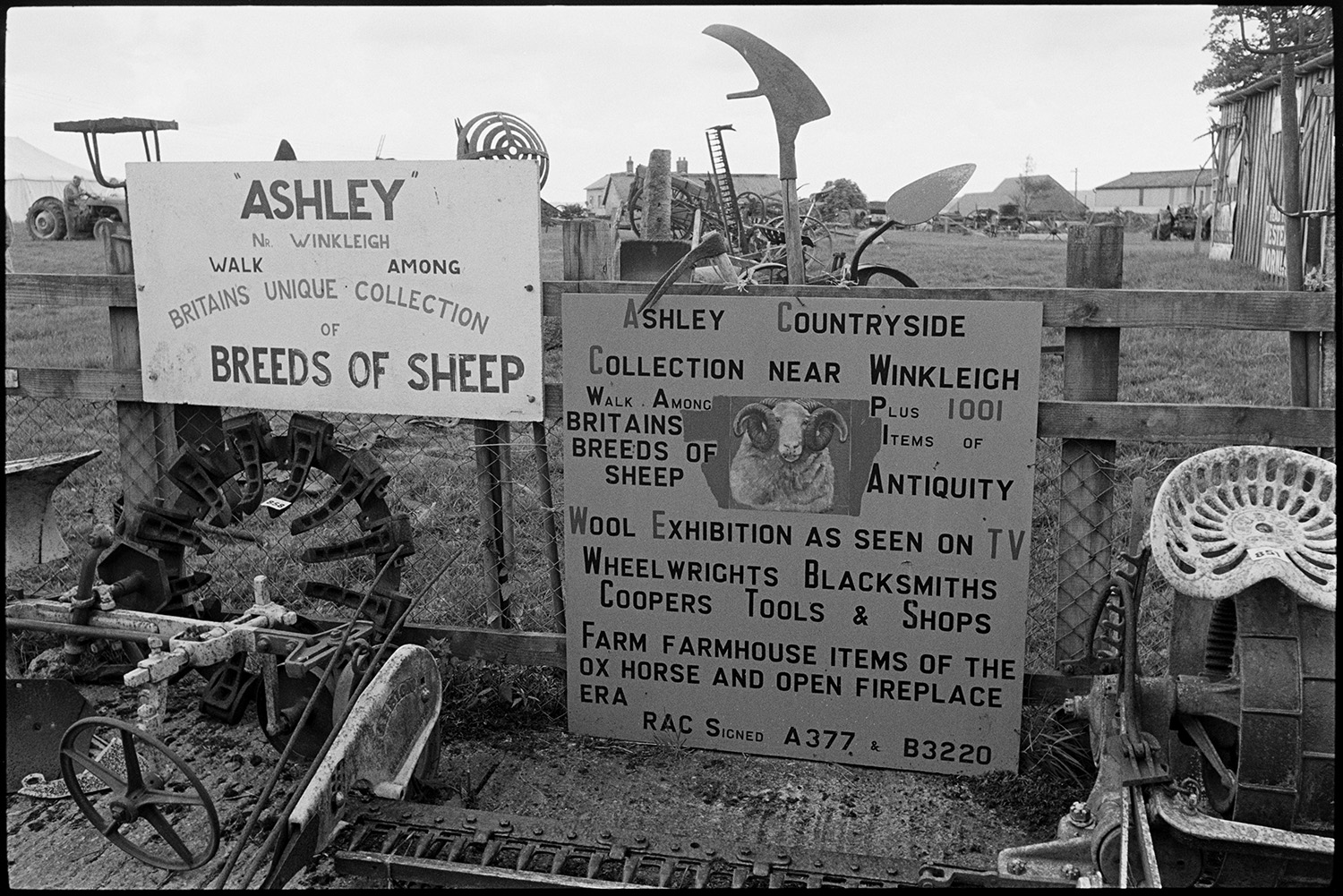 Sale of agricultural museum collection, signs, implements, machinery on display. Woodpile.
[Signs giving details of the attractions at the Ashley Countryside Collection, surrounded by old agricultural machinery.]