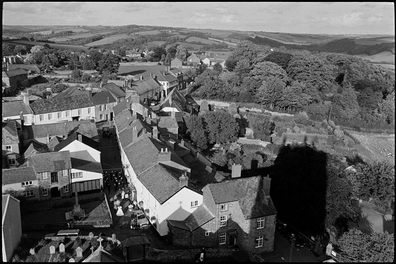 A view from Chulmleigh Church tower of houses in the town below. The Fair Queen can be seen processing behind a brass band, past the war memorial, to Chulmleigh Fair.
