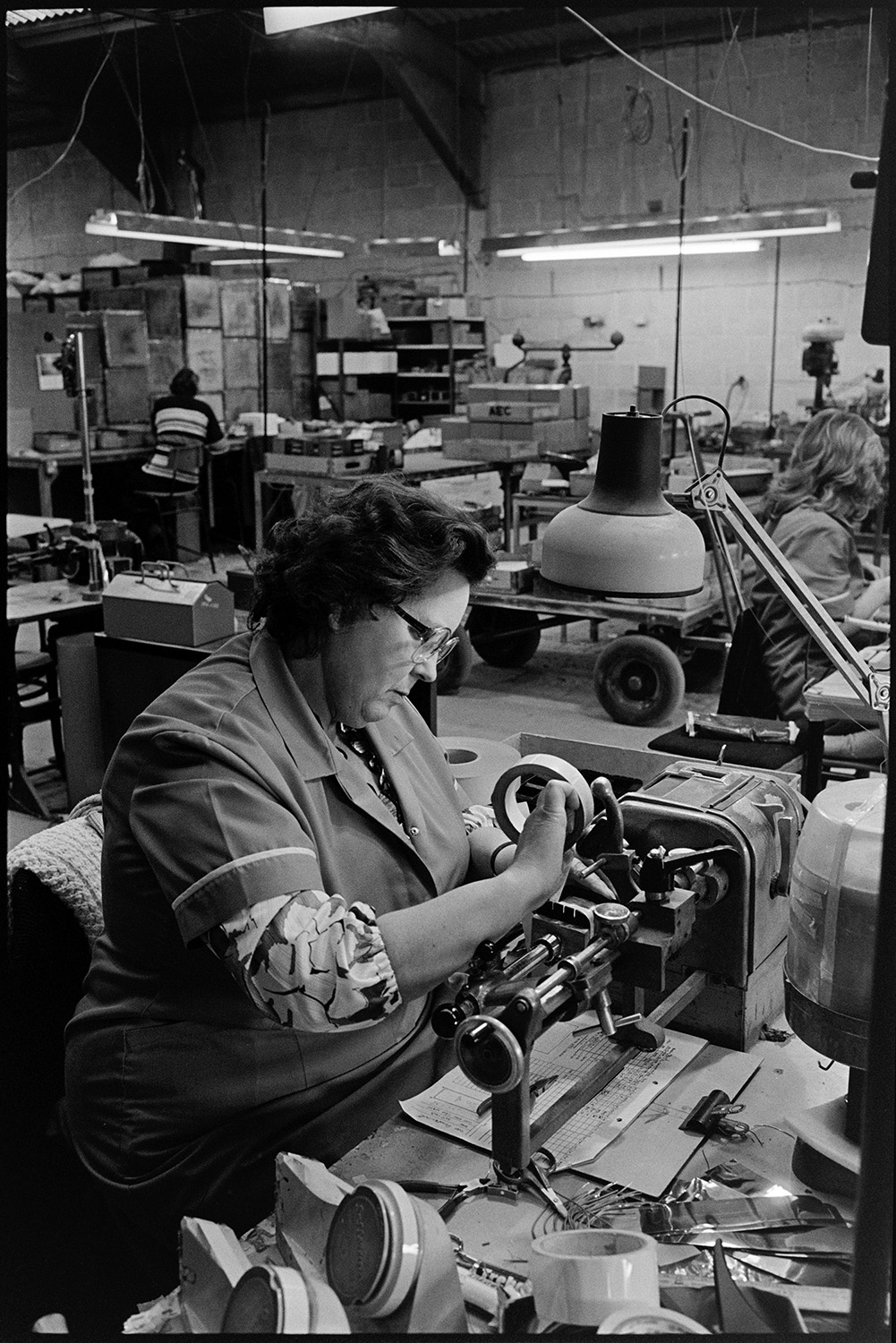 Inside transformer factory men and women making, designing transformers, computer. 
[A woman working with machinery at Apex Transformers at Pathfields Business Park in South Molton.]