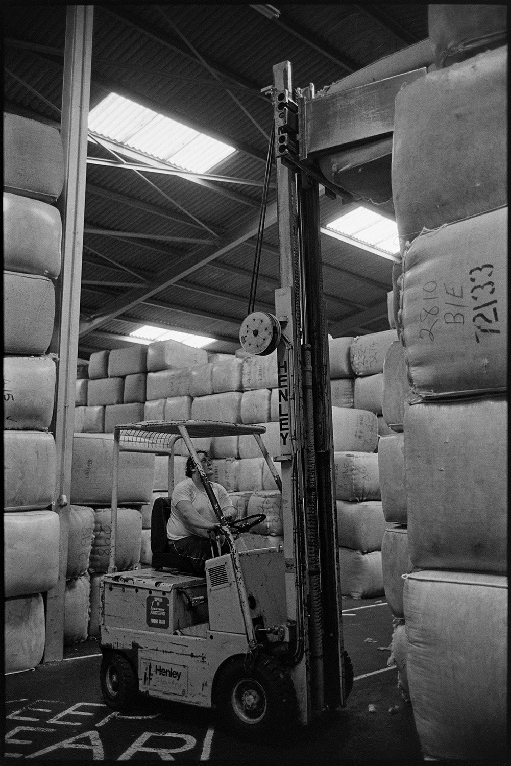 Men sorting and packing wool in warehouse.
[Man driving a forklift truck stacking bales of wool in a warehouse for Devon & Cornwall Wools Ltd at the Pathfields Business Park in South Molton.]