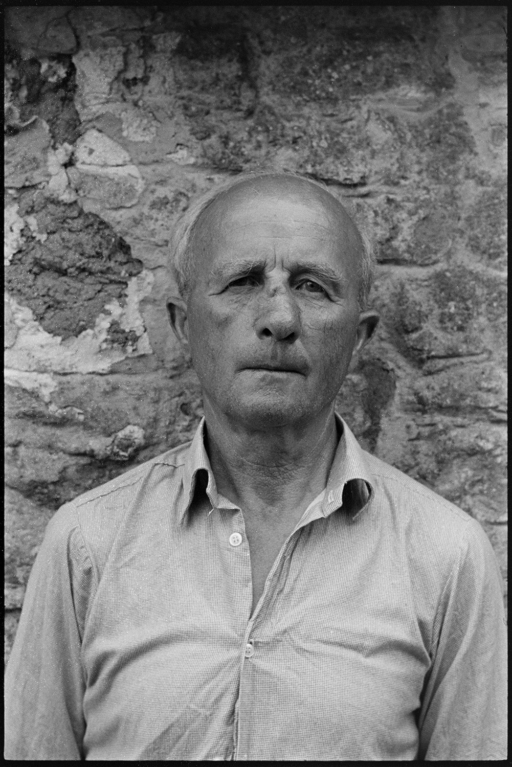 Portrait for document commission. 
[A portrait of Bill Hammond, a thatcher, stood by a stone wall at Rashleigh Mill, Bridge Reeve.]