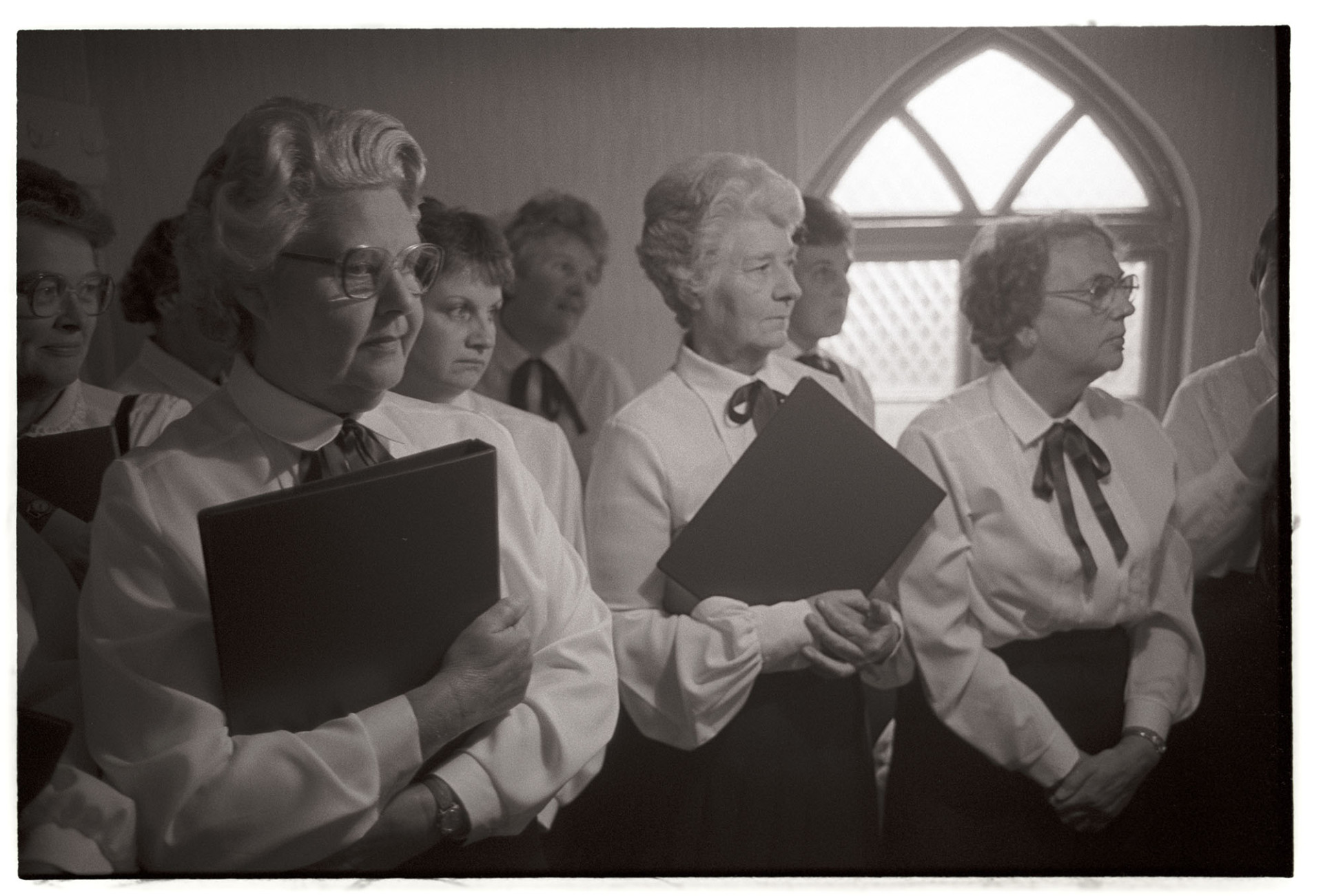 Harvest Festival, women, ladies choir before service. 
[The women of Chulmleigh Congregational Chapel choir before the Harvest Festival service. They are all holding folders with their music.]
