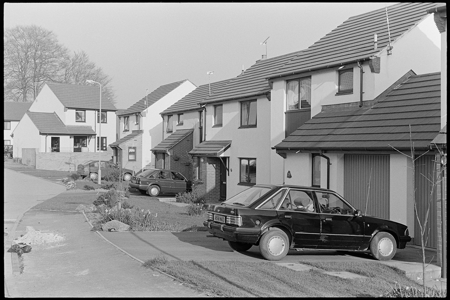 New housing estate. 
[A new housing estate in South Molton. Detached and semi-detached houses are visible. Some have cars parked on the driveways.]