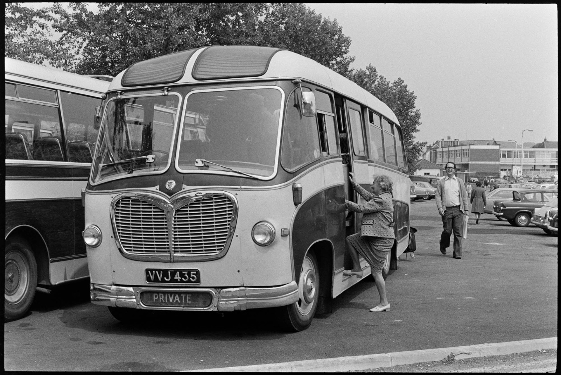Turner's bus from Chulmleigh parked at Barnstaple.<br />
[A woman getting onto Turner's bus which travelled to and from Varnstaple market. Rcihard Davin is walking towards the bus. Other parked cars and shoppers are in the background.]