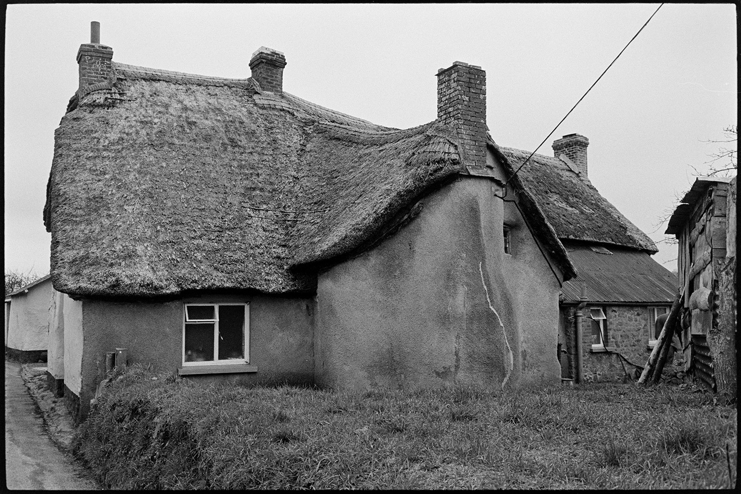 Cottage, cob and thatch, good interesting shape. 
[A cob and thatch cottage at Monkokehampton with an oddly shaped roof.]