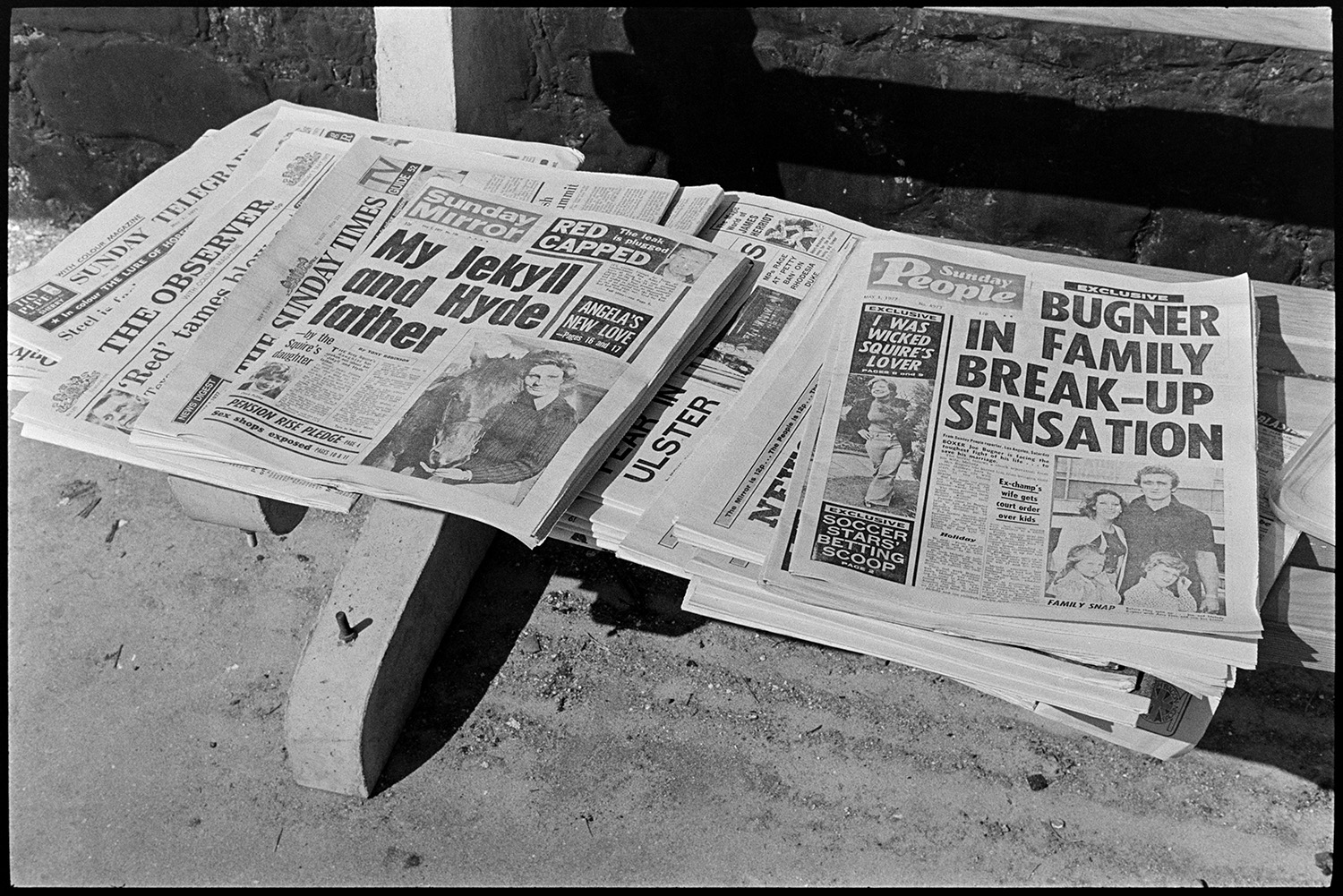 Sunday papers for sale in village, front pages! 
[A pile of Sunday newspapers for sale in Kings Nympton, Newspapers include the Sunday Telegraph, The Observer, The Sunday Times, Sunday Mirror and Sunday People. The front pages of some of the newspapers are visible.]