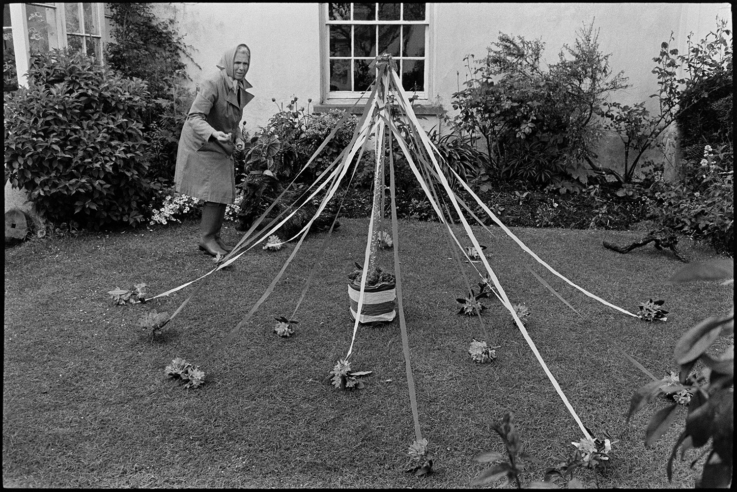 People decorating houses and gardens on Jubilee day! 
[Marge Knight decorating her garden at Arscotts, Dolton with a miniature maypole and flowers on Queen Elizabeth II Silver Jubilee day.]