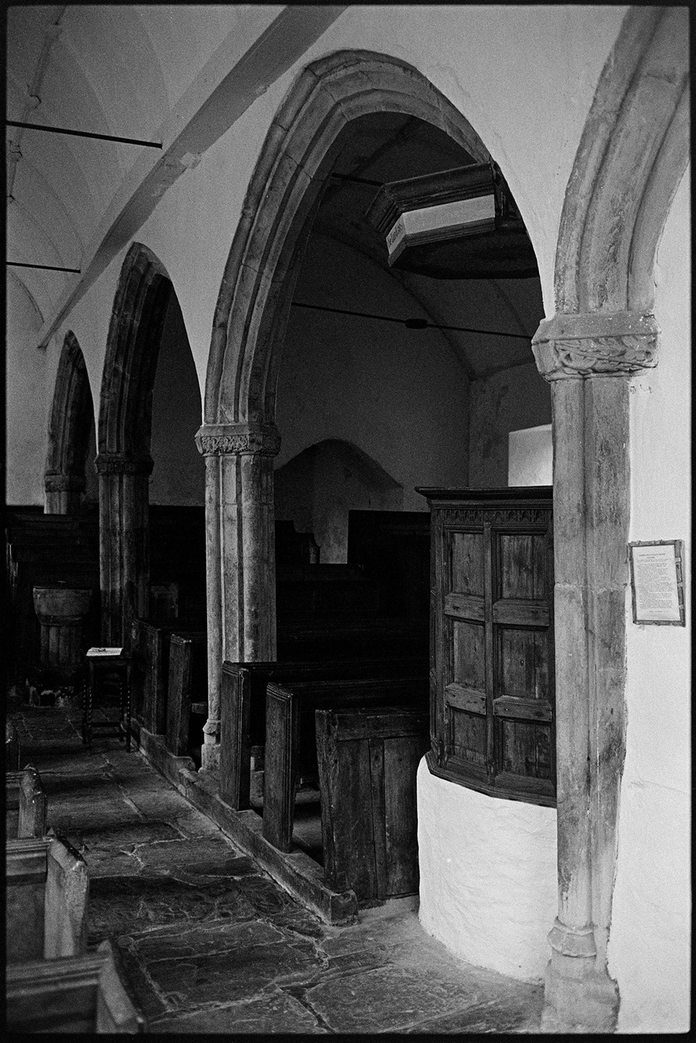 Interior and exterior of redundant church.
[The interior of a redundant church at Parracombe, showing stone arches, a wooden pulpit and pews, and a flagstone floor.]