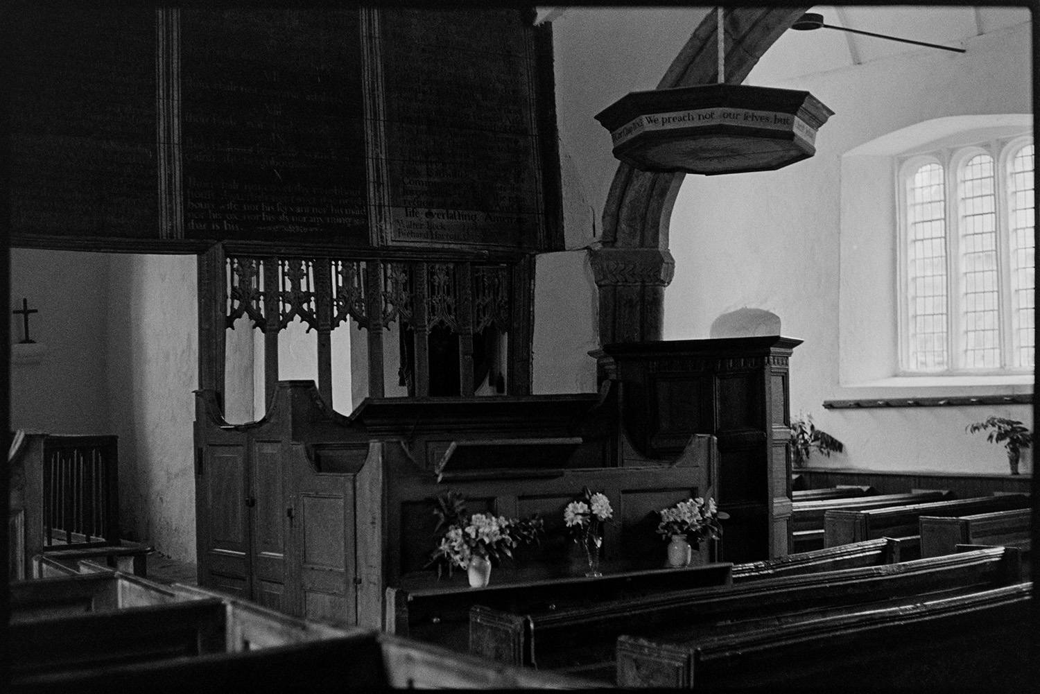 Interior and exterior of redundant church.
[The interior of a redundant church at Parracombe showing wooden pews, a wooden pulpit with a hood and floral decorations.]