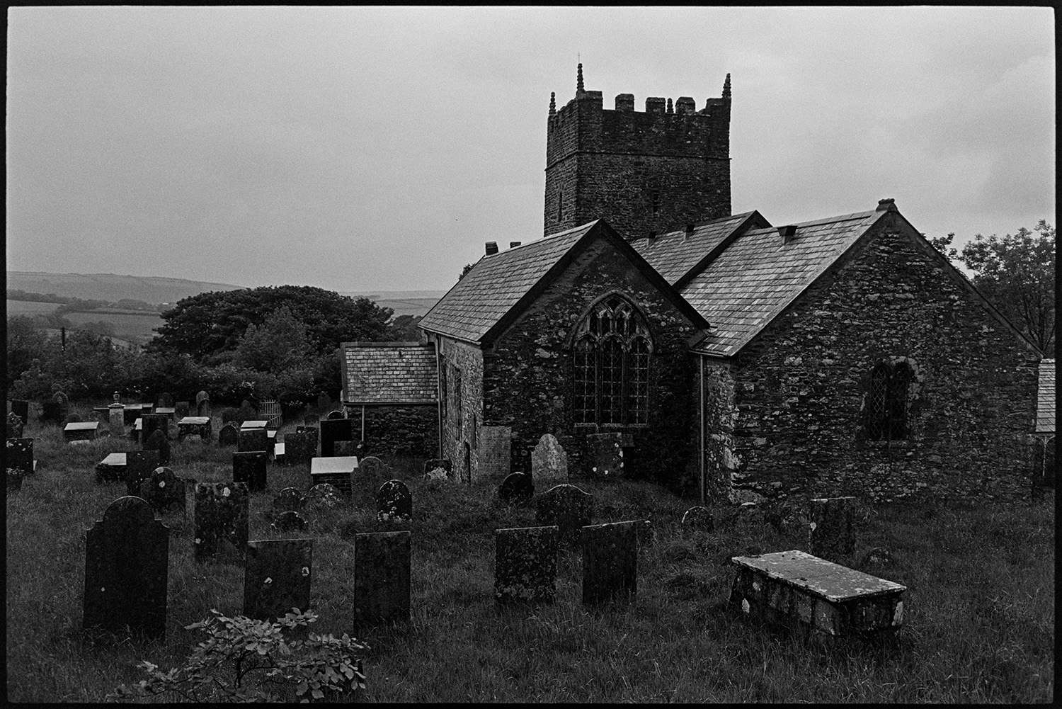 Interior and exterior of redundant church.
[View of the churchyard with tombstones and gravestones and the exterior of a redundant church with a tower at Parracombe.]