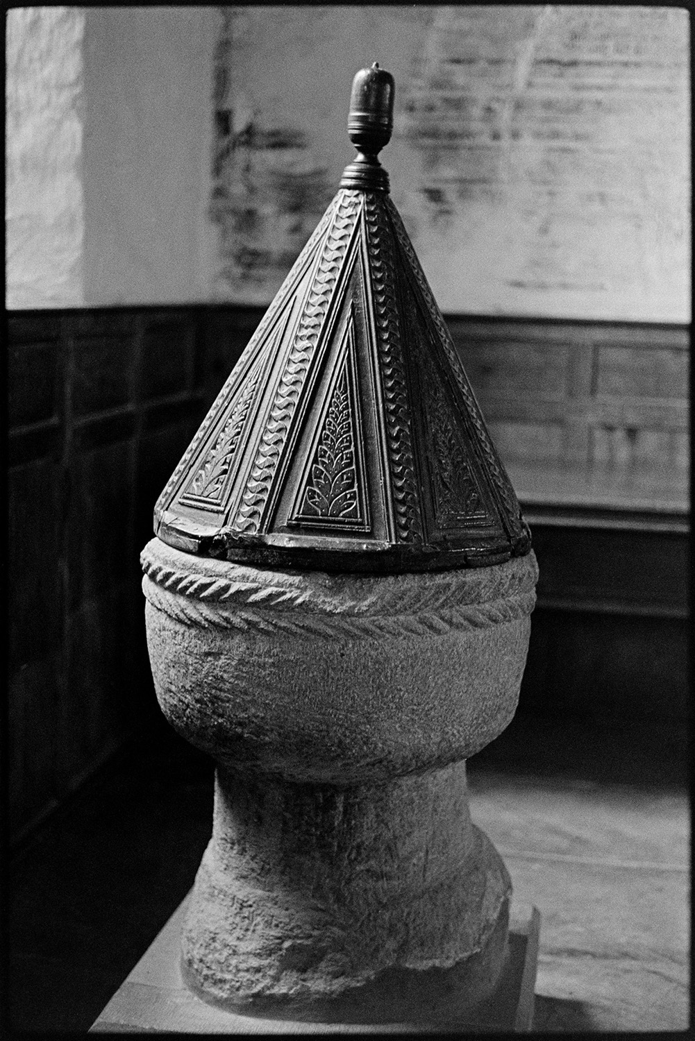 Norman font with conical wood cover. 
[A Norman font with a cone shaped carved wooden cover in Launcells Church.]