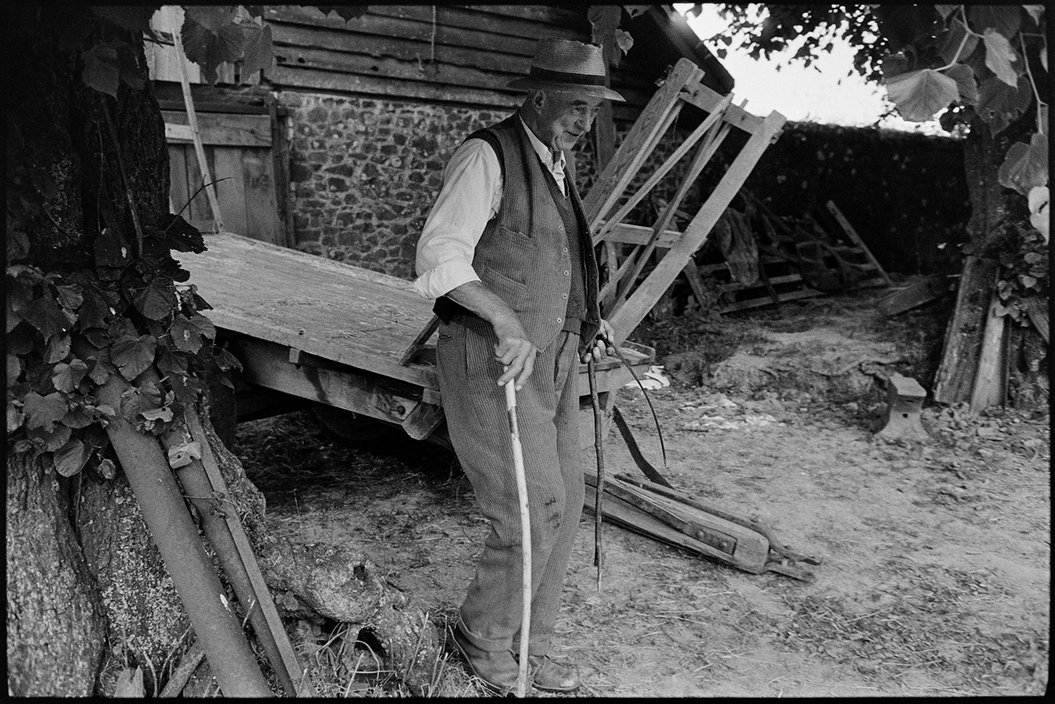 Various groups and shots of farming family. 
[Mr Crocker walking past a trailer and barn at Deckport, Hatherleigh. He is using a walking stick.]