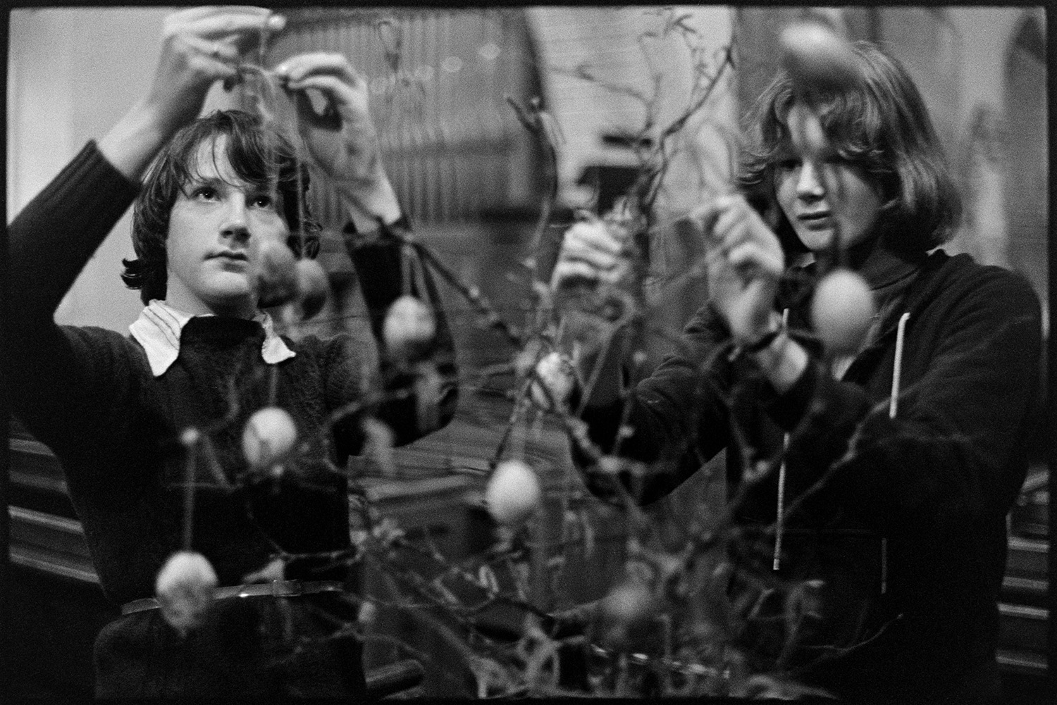Women decorating church for Easter.
[Two young women decorating tree branches with eggs for Easter in Dolton Church.]