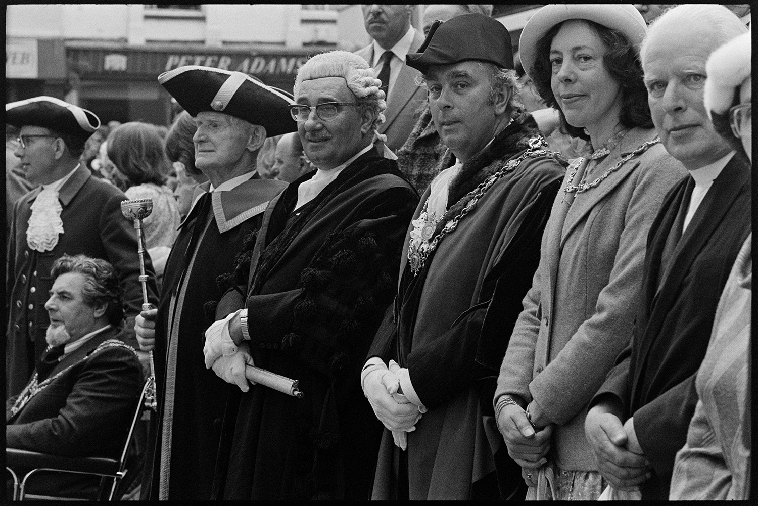 Mayors, wives and dignitaries in square looking at Mayfair parade. 
[Mayors, dignitaries and wives in Torrington square, watching the Mayfair parade. Dr Cramp is wearing his mayoral chain of office and a bicorne hat.]