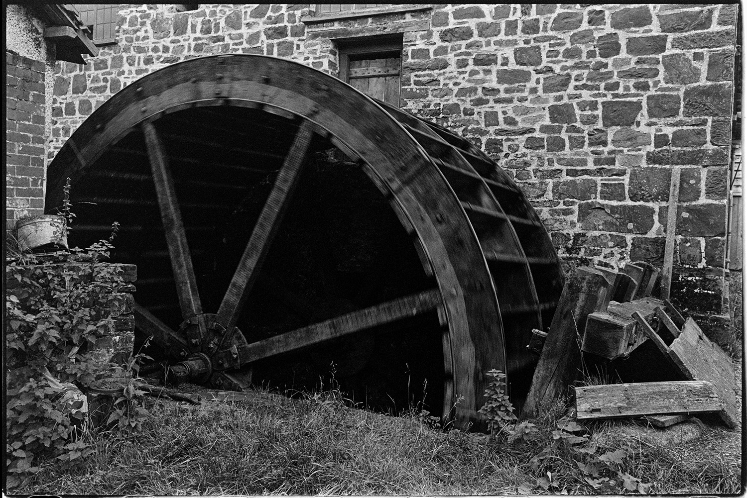 Mill wheel. 
[A wooden water wheel by the stone mill building at Head mill, Kings Nympton.]
