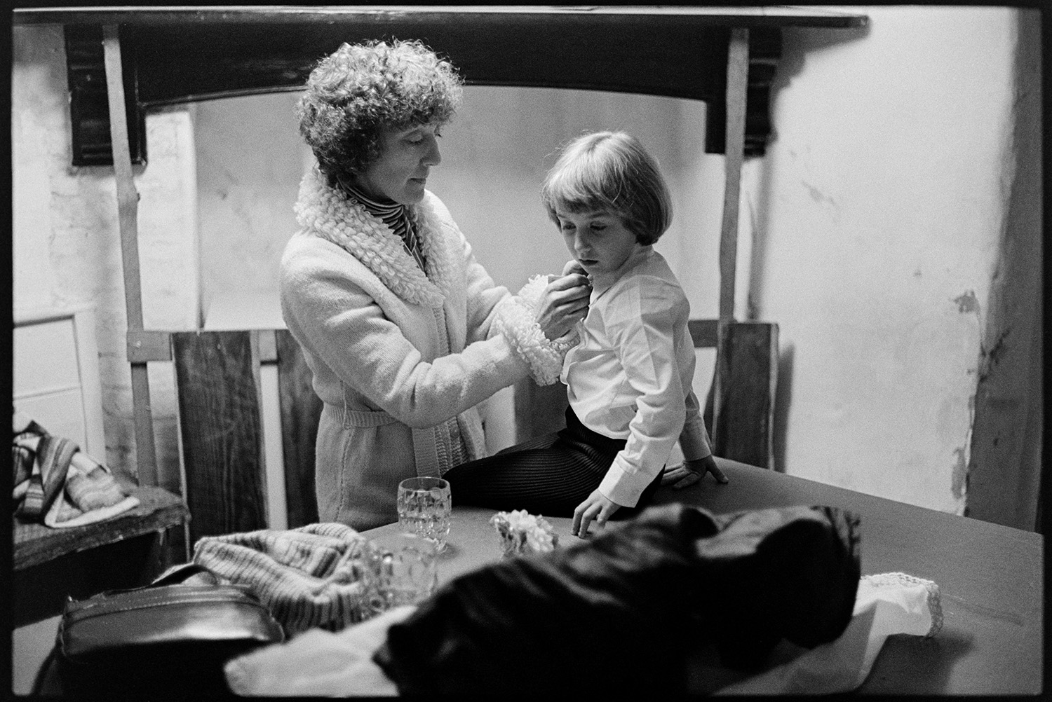 A woman dressing a child sat on a table, possibly for Hatherleigh Carnival.