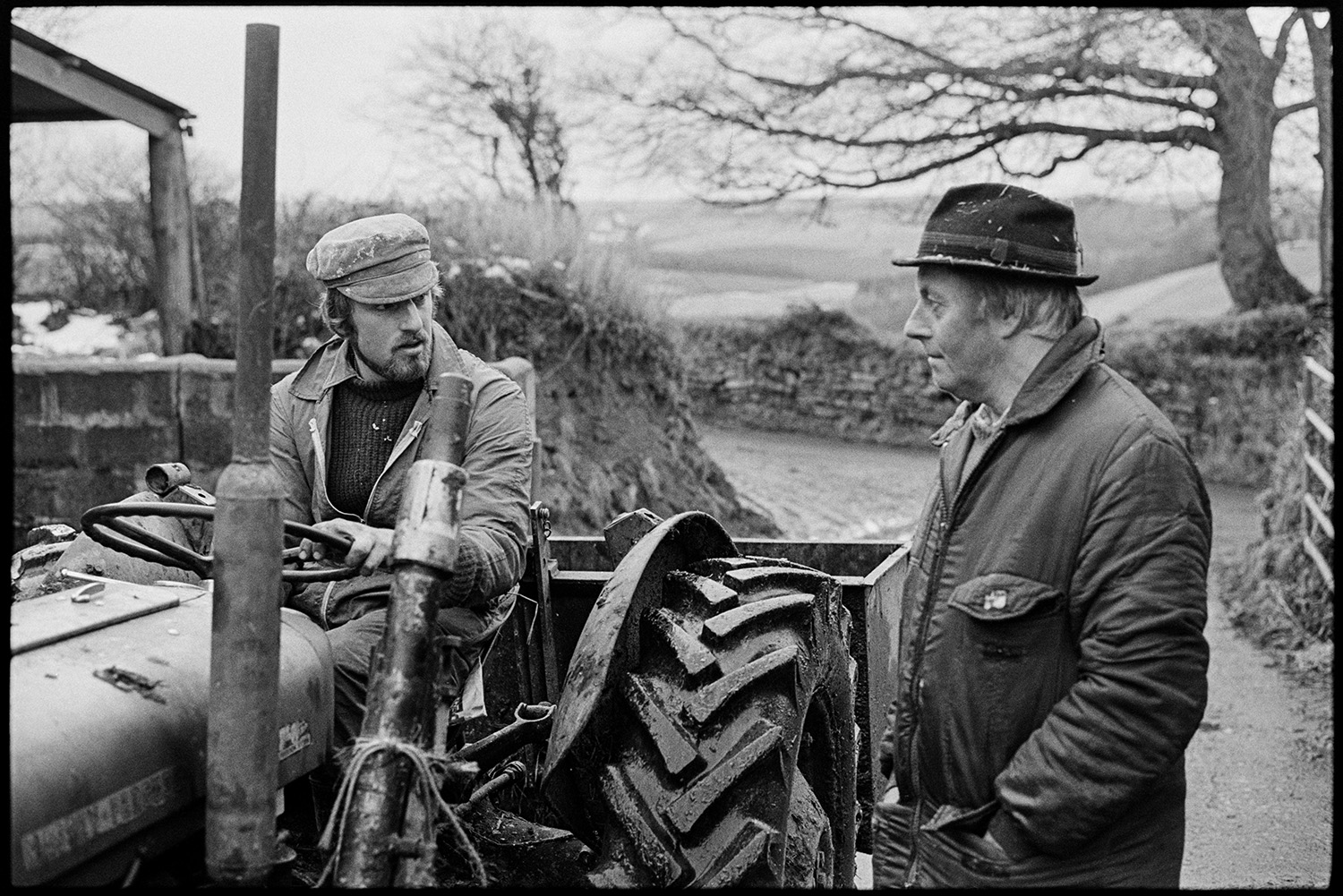 Farmers feeding cows, checking new born calves. 
[Simon Berry, driving a tractor, and talking to Alan Berry in a lane at South Harepath, Beaford.]